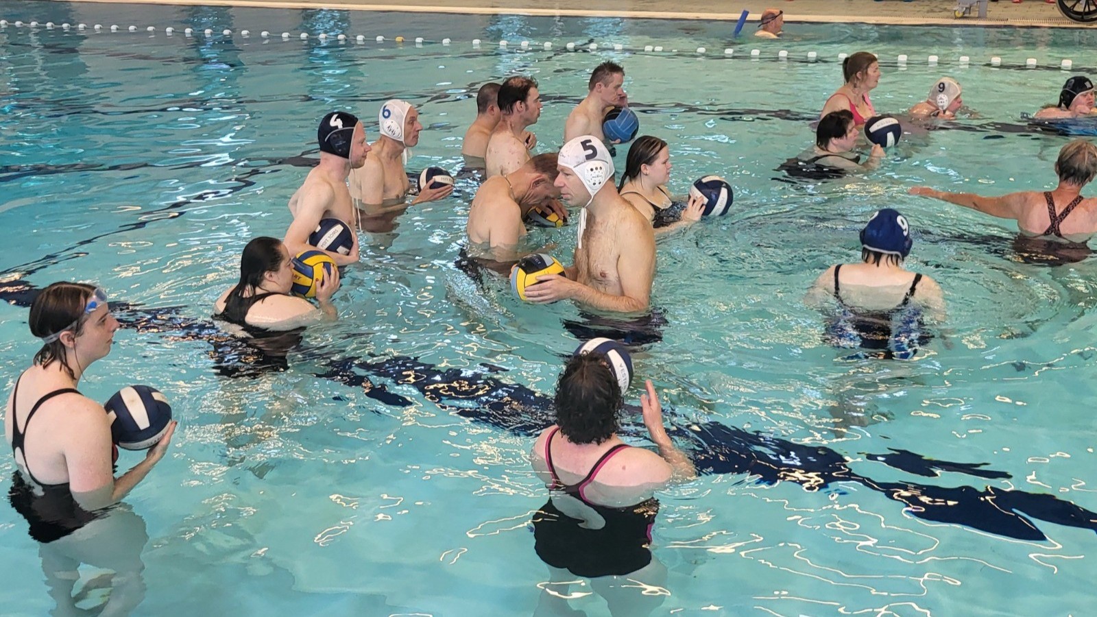Mensen met waterpolo caps in een zwembad